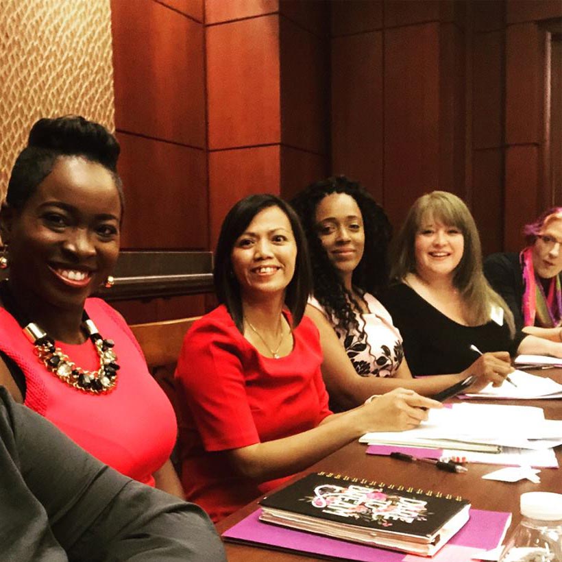 Image shows a well-dressed, smiling group of survivors sitting at a table. They are survivors who are doing work on behalf of the NSN.